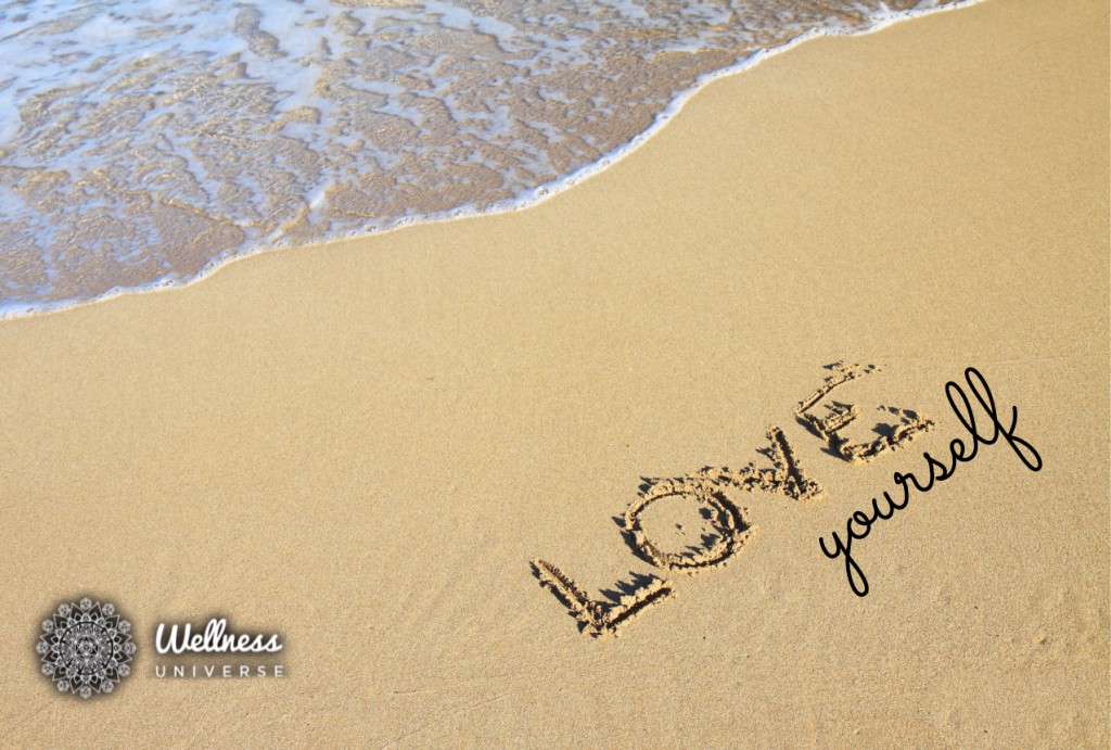 Love yourself written in sand on a beach