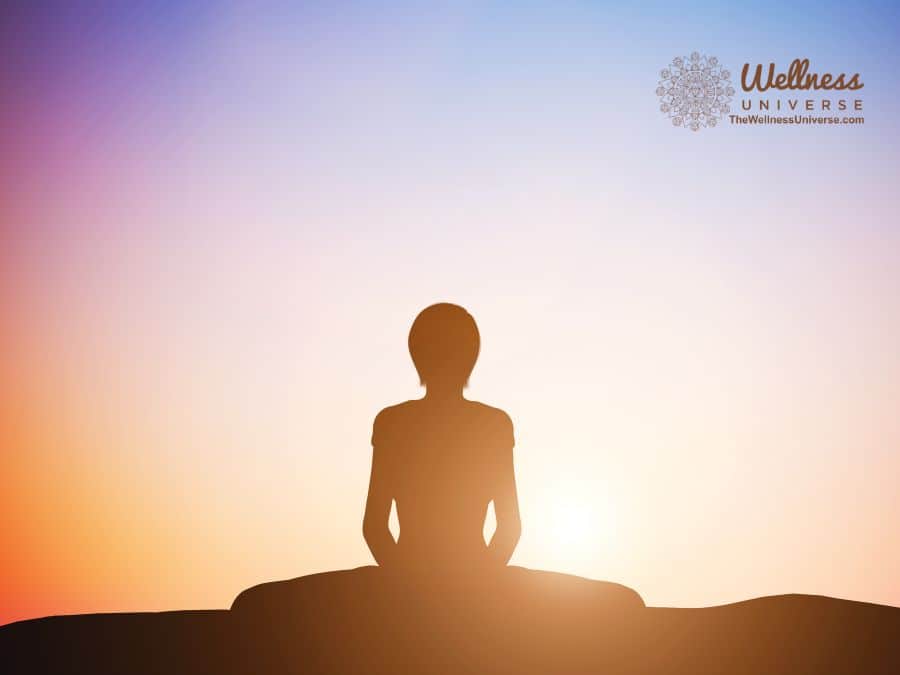 woman meditating at sunrise